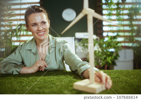 smiling business woman in green blouse in green office 107688814