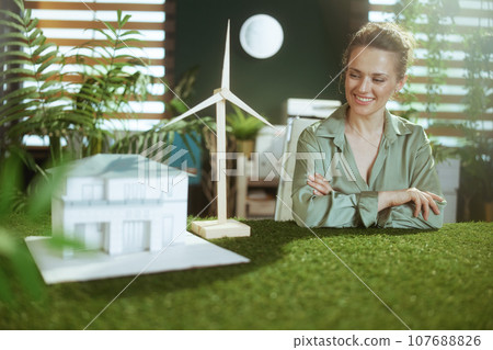 happy business owner woman in green blouse in green office 107688826