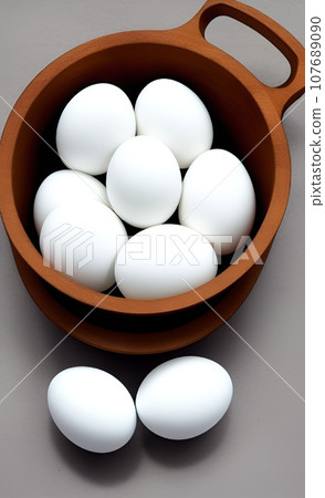 white eggs in a wooden bowl 107689090