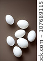 isolated white eggs on black background 107689115