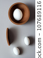 white egg in wood bowl on white background 107689116