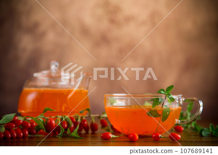Prepared drink from ripe goji berries in a glass cup and teapot Prepared drink from ripe goji berries in a glass cup and teapot 107689141
