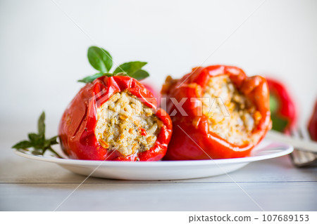 stewed in gravy stuffed peppers in a plate . 107689153