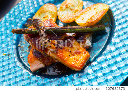 Dish of tasty steak of fried salmon with potatoes and asparagus Dish of tasty steak of fried salmon with potatoes and asparagus 107689873