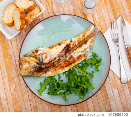 Fresh baked fish sea bass with arugula Fresh baked fish sea bass with arugula 107689890
