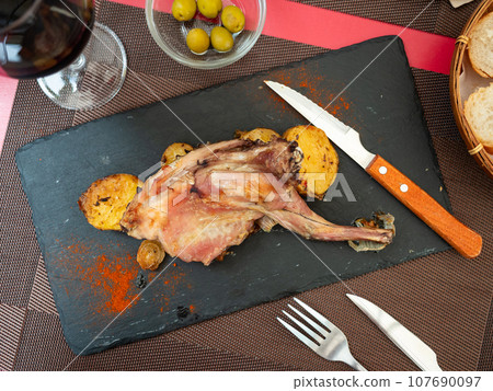 rabbit with potatoes on serving board rabbit with potatoes on serving board 107690097