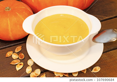 Pumpkin hot puree soup on a wooden table Pumpkin hot puree soup on a wooden table 107690684