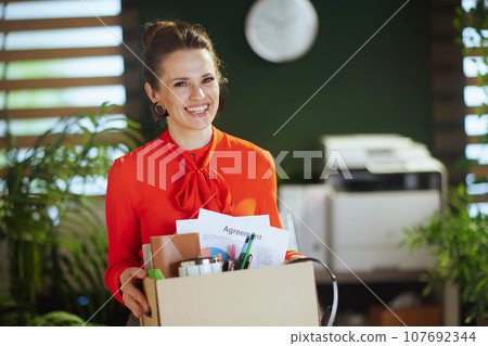 happy 40 years old woman employee in green office 107692344