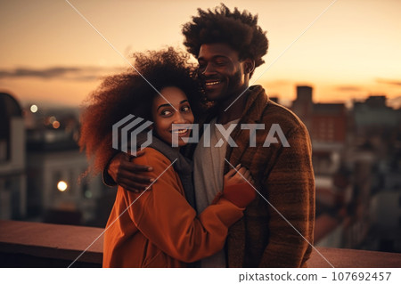 Young happy couple in love on roof of multi-storey building. Cute curly-haired african man hugs his charming mixed race girlfriend. Generated by AI. 107692457