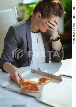 stressed modern bookkeeper woman in modern green office stressed modern bookkeeper woman in modern green office 107693033