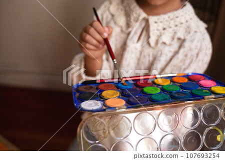 little cute girl draws with paints on canvas at the easel. little cute girl draws with paints on canvas at the easel. 107693254