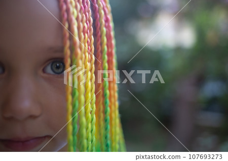 portrait of a little beautiful girl with multi-colored african braids portrait of a little beautiful girl with multi-colored african braids 107693273