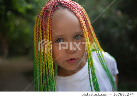 portrait of a little beautiful girl with multi-colored african braids portrait of a little beautiful girl with multi-colored african braids 107693274