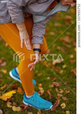 Modern woman in fitness clothes in park having leg pain Modern woman in fitness clothes in park having leg pain 107693752