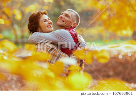smiling romantic boyfriend and girlfriend in park hugging smiling romantic boyfriend and girlfriend in park hugging 107693901