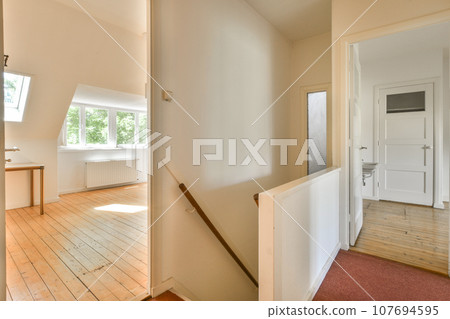 an empty room with wood floors and white walls, there is a staircase leading up to the second floor in this photo 107694595
