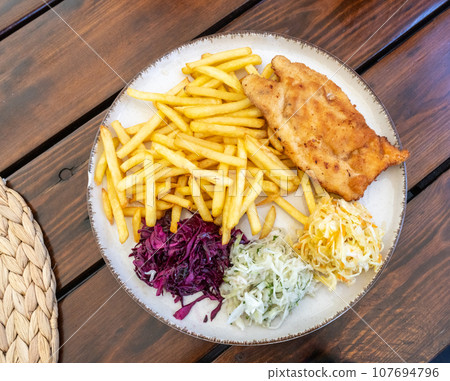 Traditional Polish Chop, Breaded Cutlet, Roasted Pork Steak in Breadcrumbs with Fresh Cabbage Salads 107694796