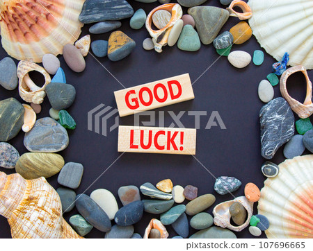 Good luck symbol. Concept words Good luck on beautiful wooden block. Beautiful black table black background. Sea stone sea shell. Business, motivational good luck concept. Copy space. Good luck symbol. Concept words Good luck on beautiful wooden block. Beautiful black table black background. Sea stone sea shell. Business, motivational good luck concept. Copy space. 107696665