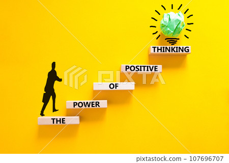 Positive thinking symbol. Concept words The power of positive thinking on wooden block. Beautiful yellow background. Businessman icon. Business, motivational positive thinking concept. Copy space. 107696707