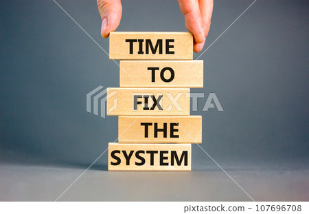 Time to fix the system symbol. Concept words Time to fix the system on wooden block. Beautiful grey table grey background. Businessman hand. Business and time to fix the system concept. Copy space. 107696708