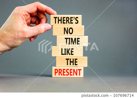 Present time symbol. Concept words There is no time like the present on wooden block. Beautiful grey table grey background. Businessman hand. Business Present time concept. Copy space. Present time symbol. Concept words There is no time like the present on wooden block. Beautiful grey table grey background. Businessman hand. Business Present time concept. Copy space. 107696714