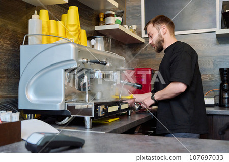 Young male barista preparing coffee in coffee shop Young male barista preparing coffee in coffee shop 107697033