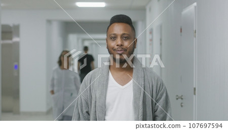 Happy African American man stands in hospital corridor 107697594