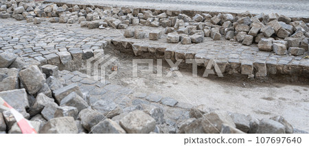 Reconstruction of Grey Old Stone Pavement, Granite Cobblestone Road under Construction 107697640