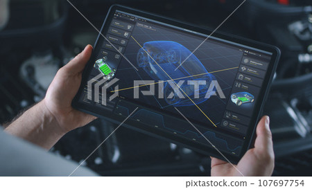Engineer holds tablet with simulation of car diagnostics displayed on screen 107697754