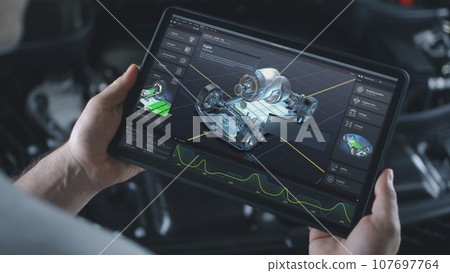 Male automotive engineer does car diagnostics using digital tablet Male automotive engineer does car diagnostics using digital tablet 107697764