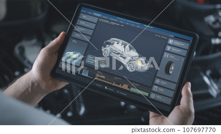 Male technician holds tablet with simulation of car diagnostics and aerodynamics 107697770
