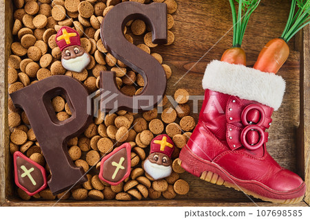 Dutch holiday Sinterklaas background. Children shoe with carrots, traditional sweets and chocolate letter 107698585