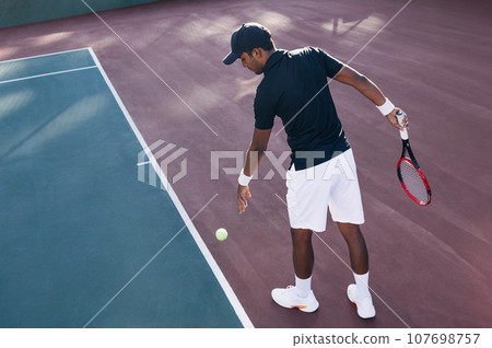 Professional tennis player on a hard court before serve Professional tennis player on a hard court before serve 107698757