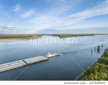 towboat with barges on the Mississippi River at confluence with the Missouri River below Alton, IL 107698945