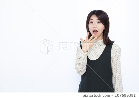 一個三十多歲的女人，在白色背景前感到驚訝 107699391