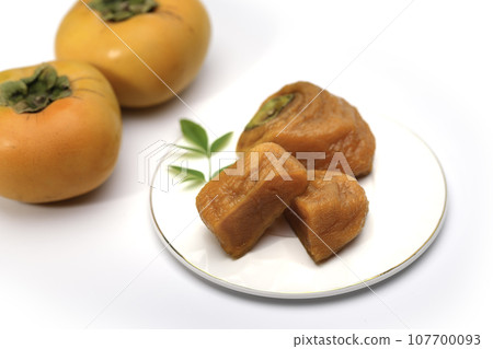 Peeling astringent persimmons and taking time to make them. Anpo persimmons. Taste of autumn. Half-ripe and sweet persimmons (white background). Fruits. Peeling astringent persimmons and taking time to make them. Anpo persimmons. Taste of autumn. Half-ripe and sweet persimmons (white background). Fruits. 107700093