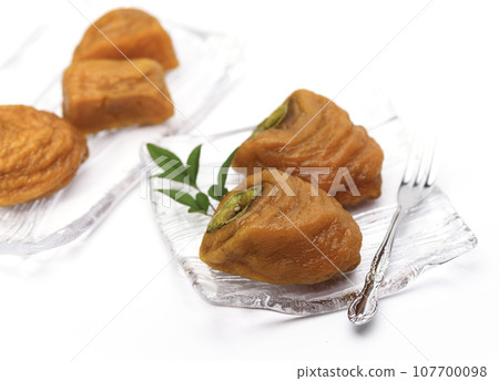 Peeling astringent persimmons and taking time to make them. Anpo persimmons. Taste of autumn. Half-ripe and sweet persimmons (white background). Fruits. 107700098