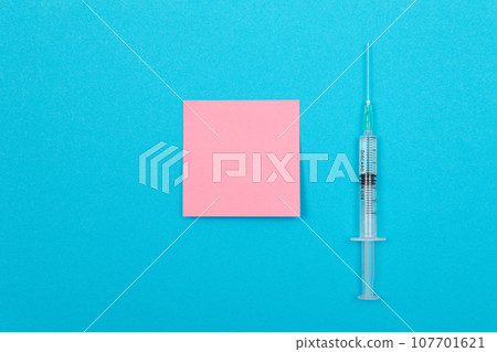 Vaccination or Revaccination Concept - A Medical Syringe on Blue Table Vaccination or Revaccination Concept - A Medical Syringe on Blue Table 107701621