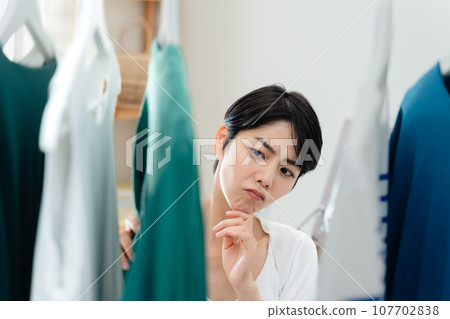 A woman preparing to go out in her room 107702838
