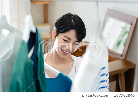A woman preparing to go out in her room A woman preparing to go out in her room 107702846