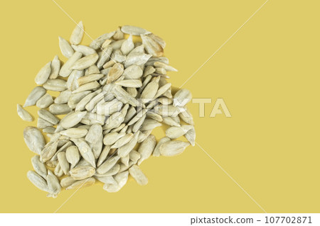 Pile of Roasted peeled sunflower seeds on isolated deep ivory background. 107702871