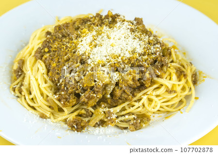 A plate of spaghetti with meat sauce and grated Parmesan cheese. A plate of spaghetti with meat sauce and grated Parmesan cheese. 107702878