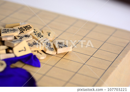 Shogi pieces piled up on the shogi board Shogi pieces piled up on the shogi board 107703221