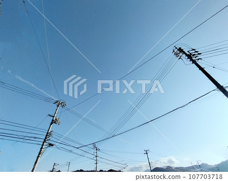 Scenery of electric wires stretching from all directions against the blue sky 107703718