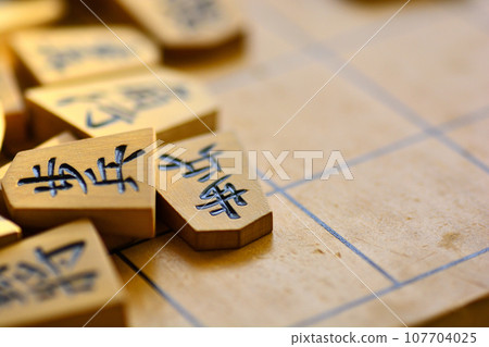 Shogi pieces stacked on the shogi board Shogi pieces stacked on the shogi board 107704025