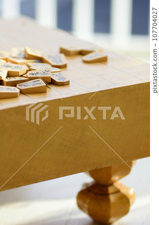 Shogi pieces stacked on the shogi board 107704027