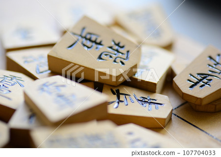 Shogi pieces stacked on the shogi board Shogi pieces stacked on the shogi board 107704033