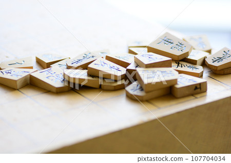Shogi pieces stacked on the shogi board Shogi pieces stacked on the shogi board 107704034