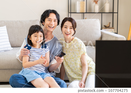 A young woman watching TV 107704275