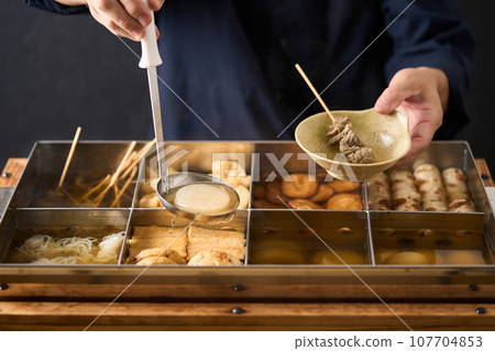 Hot oden - scoop daikon radish with a ladle Hot oden - scoop daikon radish with a ladle 107704853